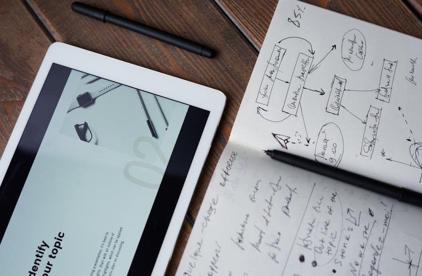 Digital and handwritten brainstorming tools on a wooden desk, ideal for business and study contexts.